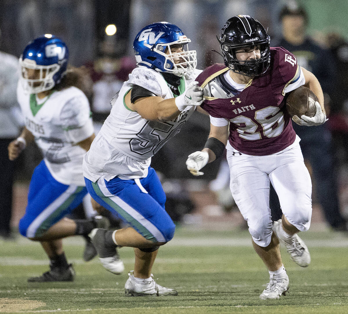 Faith Lutheran senior Nikolas Knight (26) avoids Green Valley senior Shawn Mckeon, left, during ...