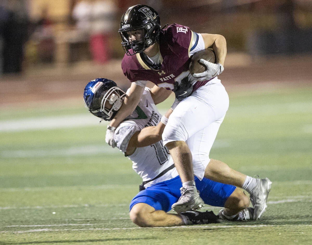 Faith Lutheran junior Justin Robbins, right, fends off Green Valley junior Roman Adams, left, d ...