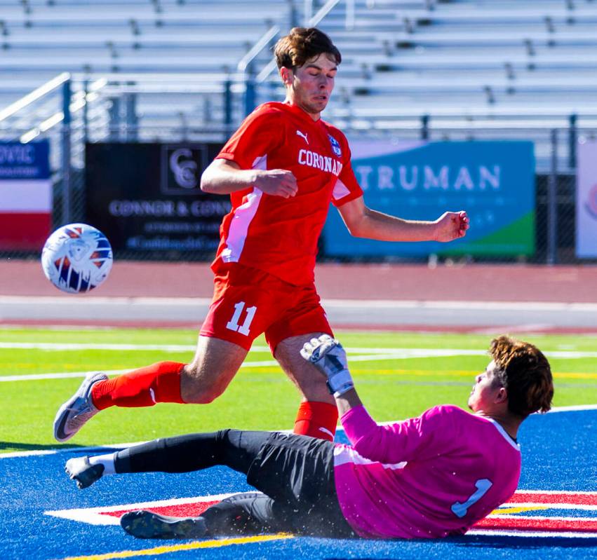 Coronado striker Gavin Flickinger (11) has the ball kicked away on a slide by Wooster goalkeepe ...