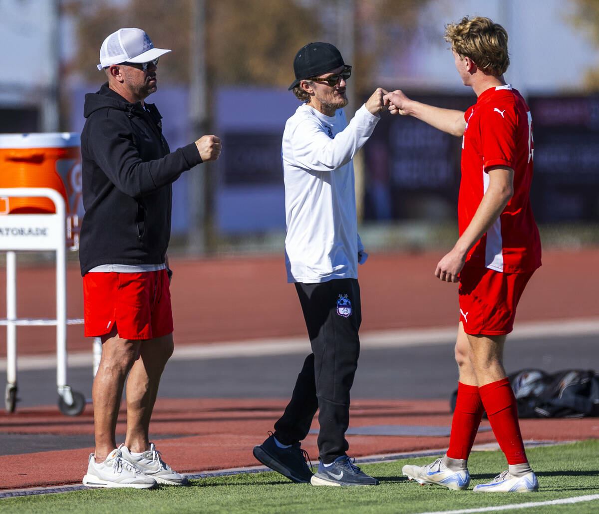 Coronado head coach Dustin Barton greets Coronado defender Ben Aronow (15) as he leaves the fie ...