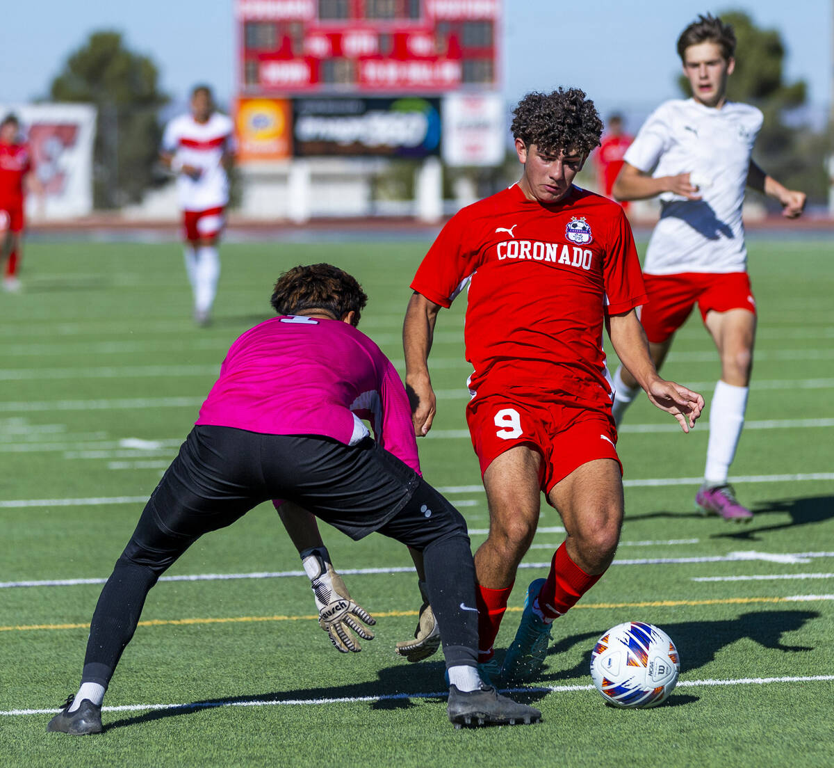 Coronado striker Dylan Flores (9) maneuvers past Wooster goalkeeper Jason Acosta Plascencia (1) ...