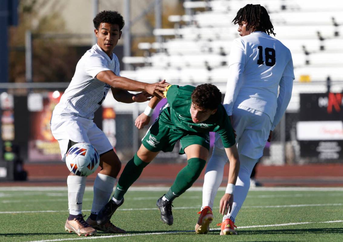 Hug High's defender Jordan Gomez (3) drives the ball between Palo Verde High's forward Trevon A ...