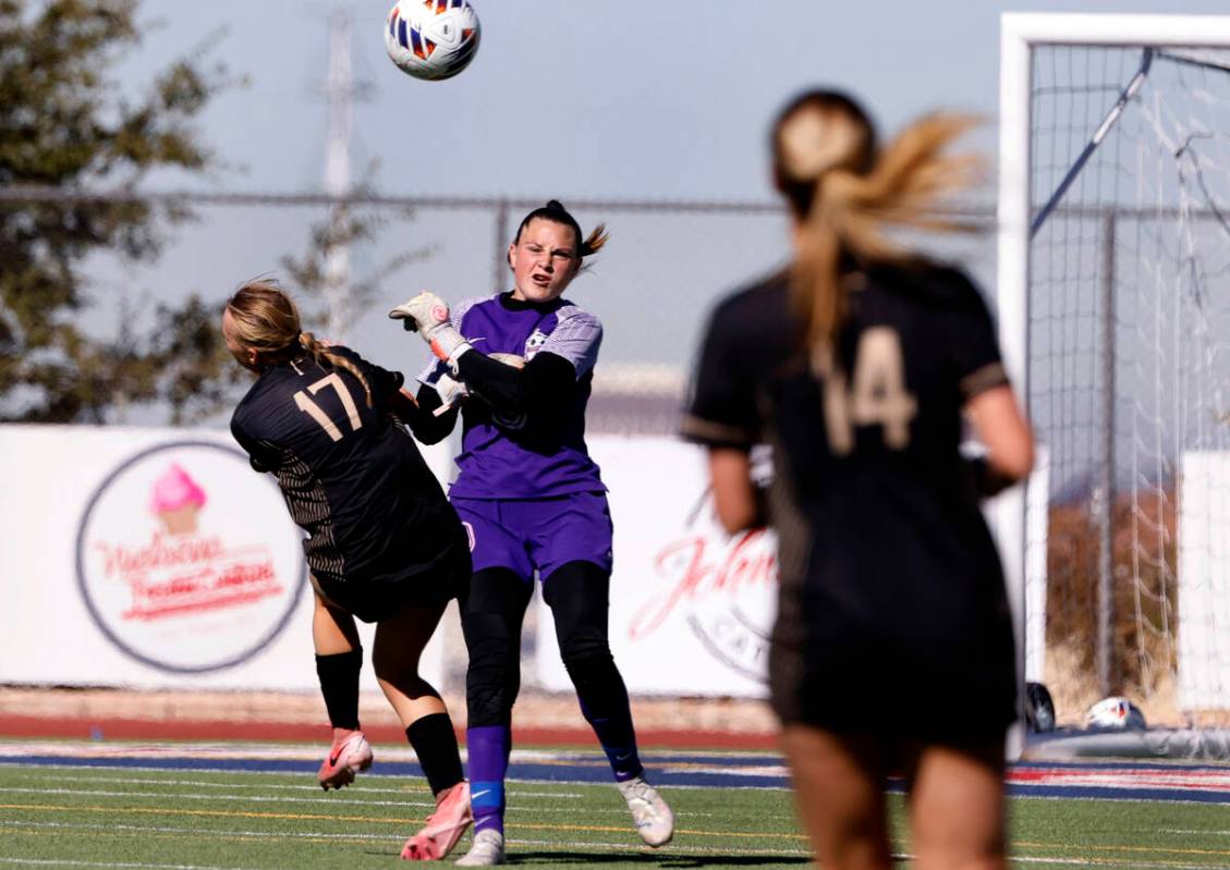 Faith Lutheran's striker Julia Anfinson (17) collides with Coronado High's goalie Eden Grenier ...