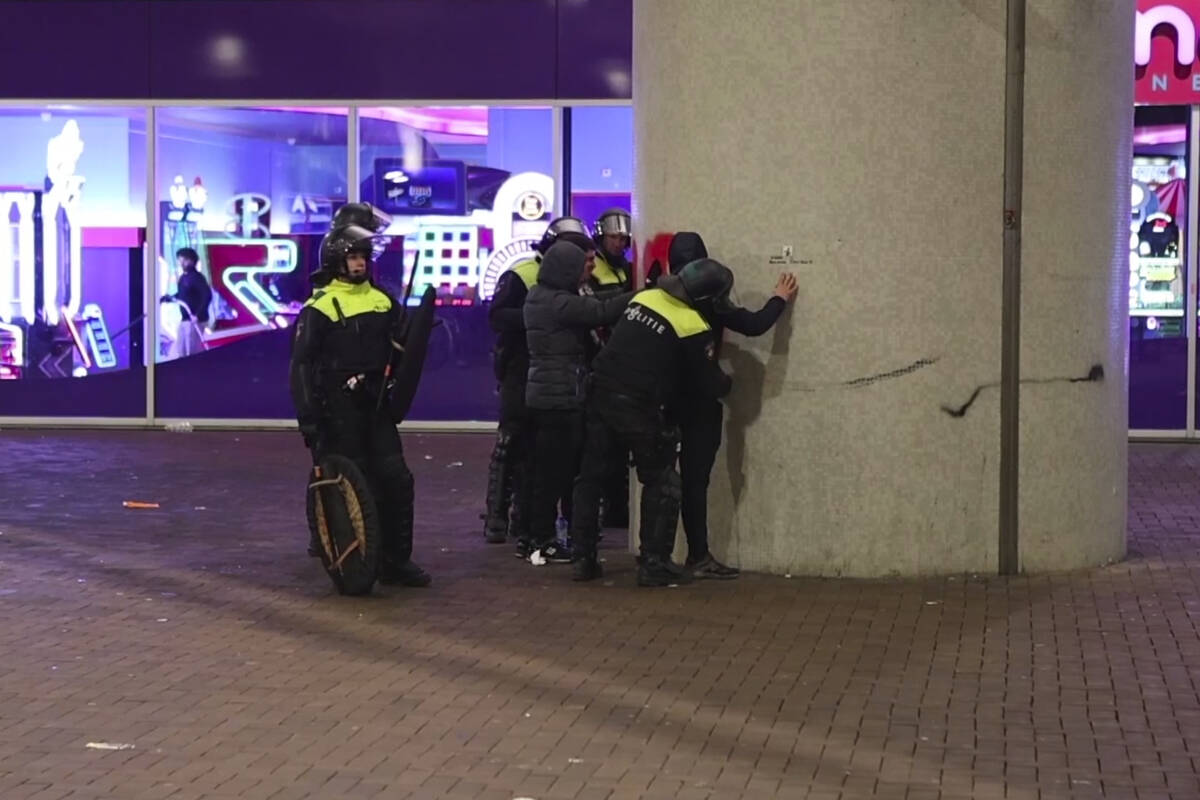 In this image taken from video, police frisk pro-Palestinian supporters near the Ajax stadium i ...