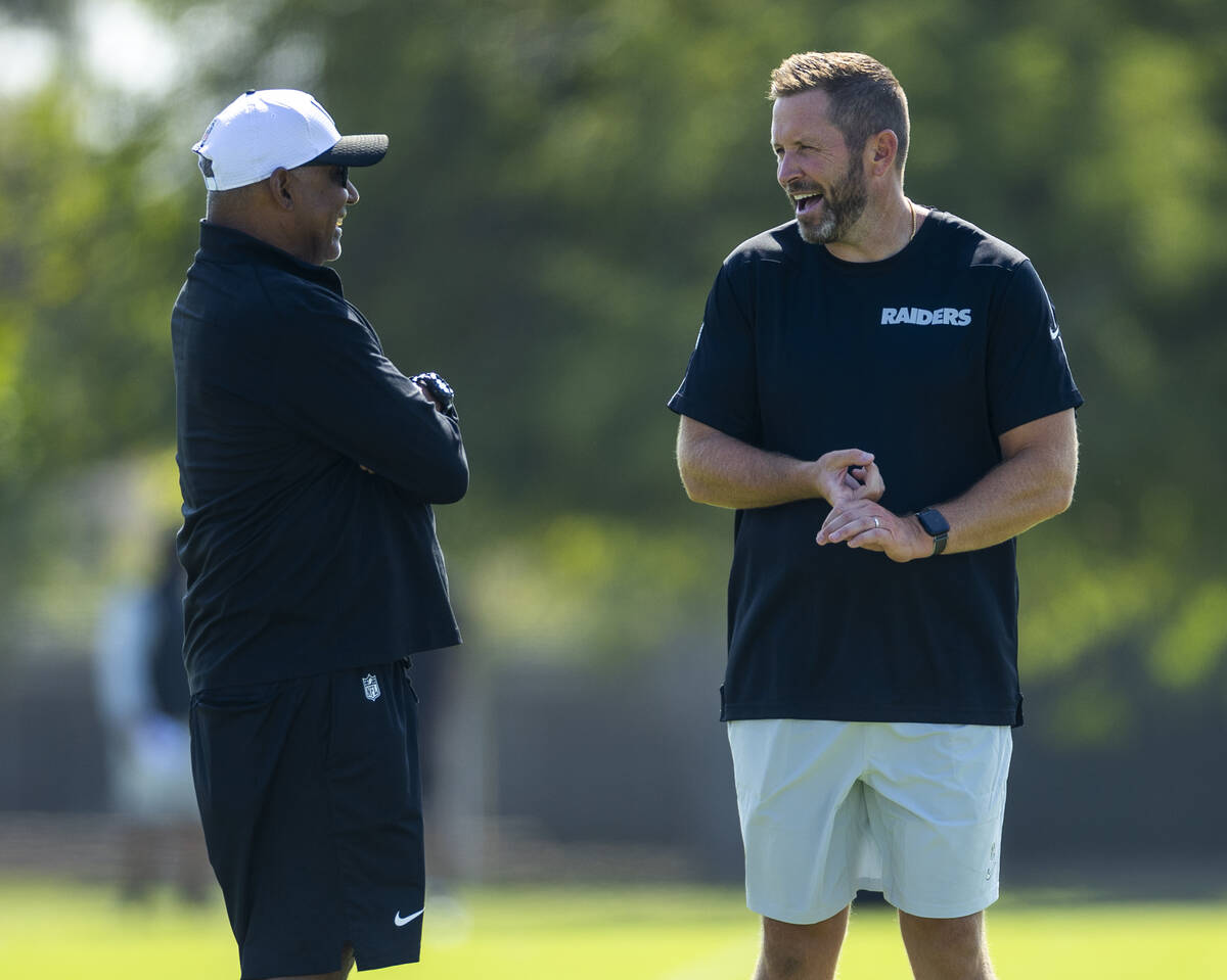 Raiders assistant head coach Marvin Lewis chats with pass game coordinator Scott Turner during ...