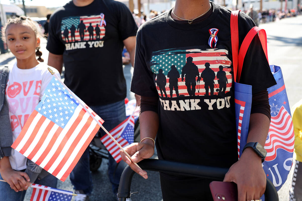 Military families with Caesars Entertainment march during the Las Vegas Veterans Day Parade dow ...