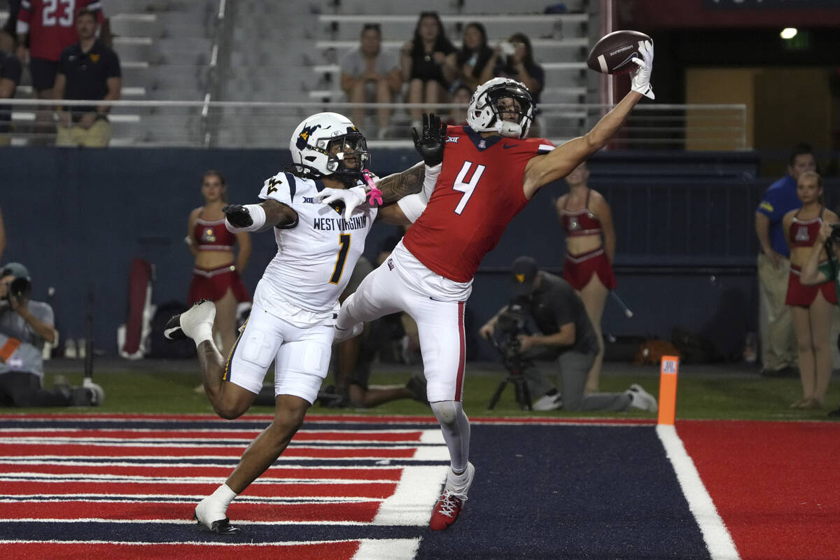 Arizona wide receiver Tetairoa McMillan (4) tries to make the catch over West Virginia cornerba ...