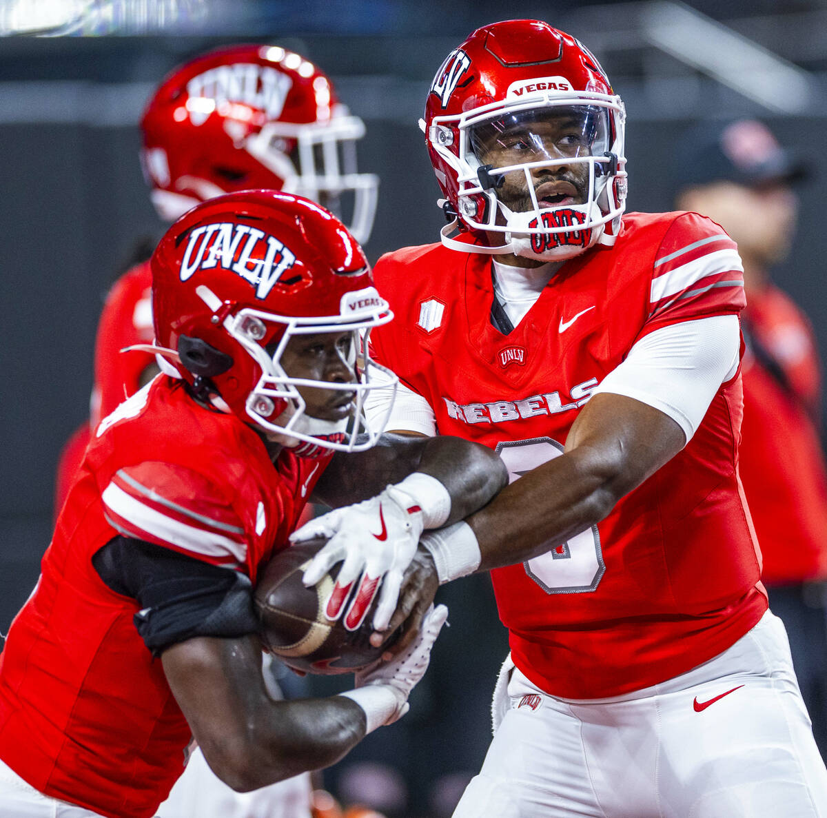 UNLV quarterback Hajj-Malik Williams (6) hands the ball to running back Jai'Den Thomas (9) duri ...