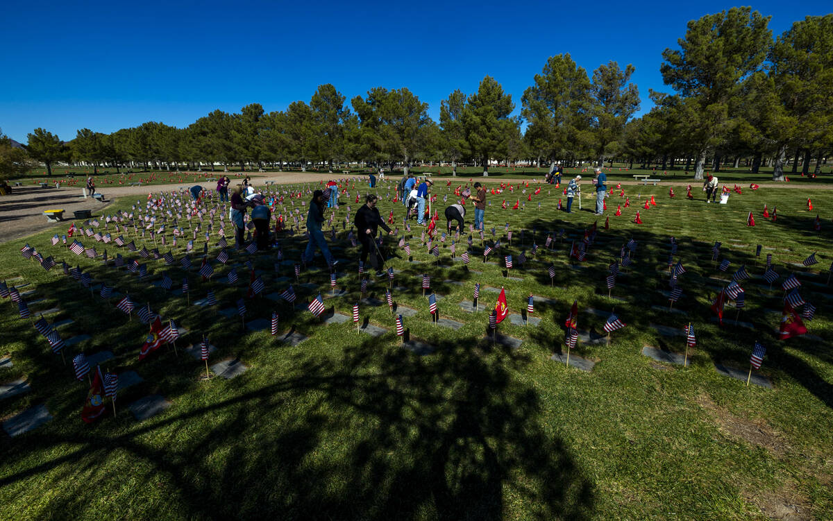 Volunteers place around 14,000 small American flags at veterans grave markers in the Southern N ...