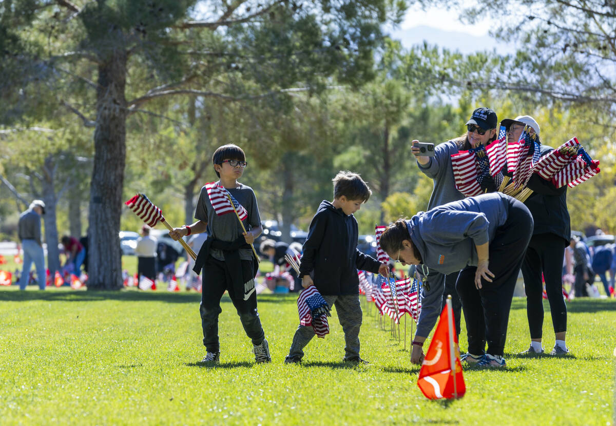 Volunteers place around 14,000 small American flags at veterans grave markers in the Southern N ...