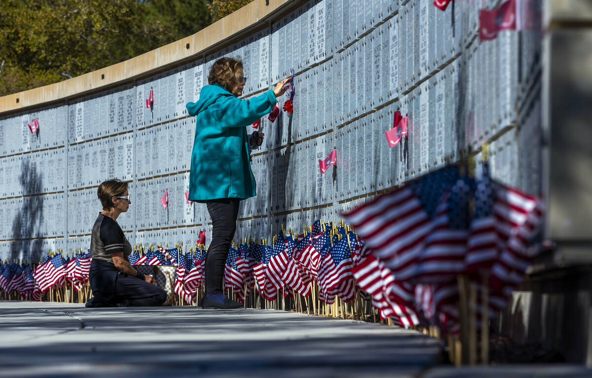 (From left) Jill D'Arpino reflects at the marker for her son Michael Kissel and Elise Tirado on ...