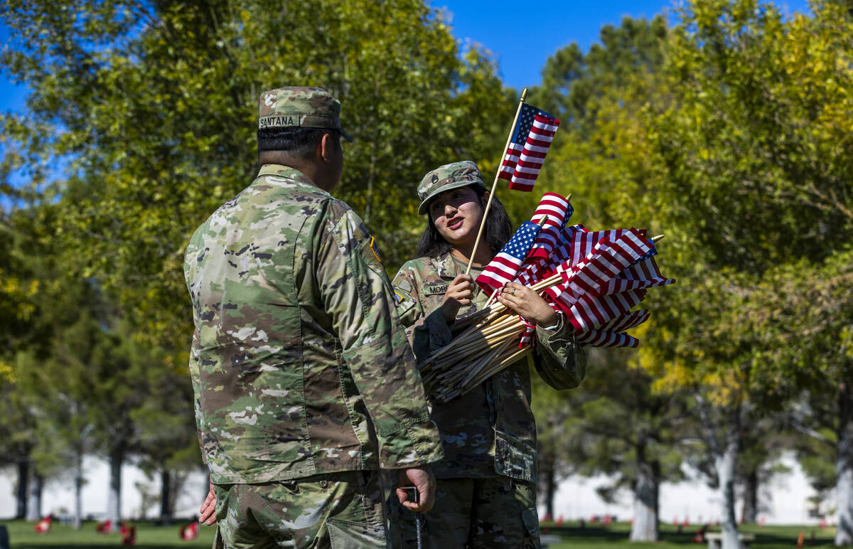 SSgt. Jessica Moreno holds a large bunch of American flags which she and SSgt. Hector Santana w ...