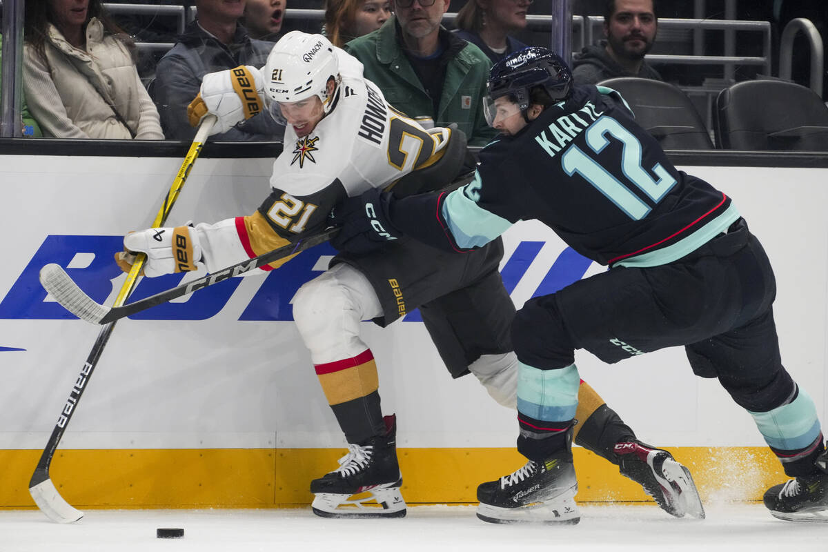 Vegas Golden Knights center Brett Howden (21) battles against Seattle Kraken left wing Tye Kart ...