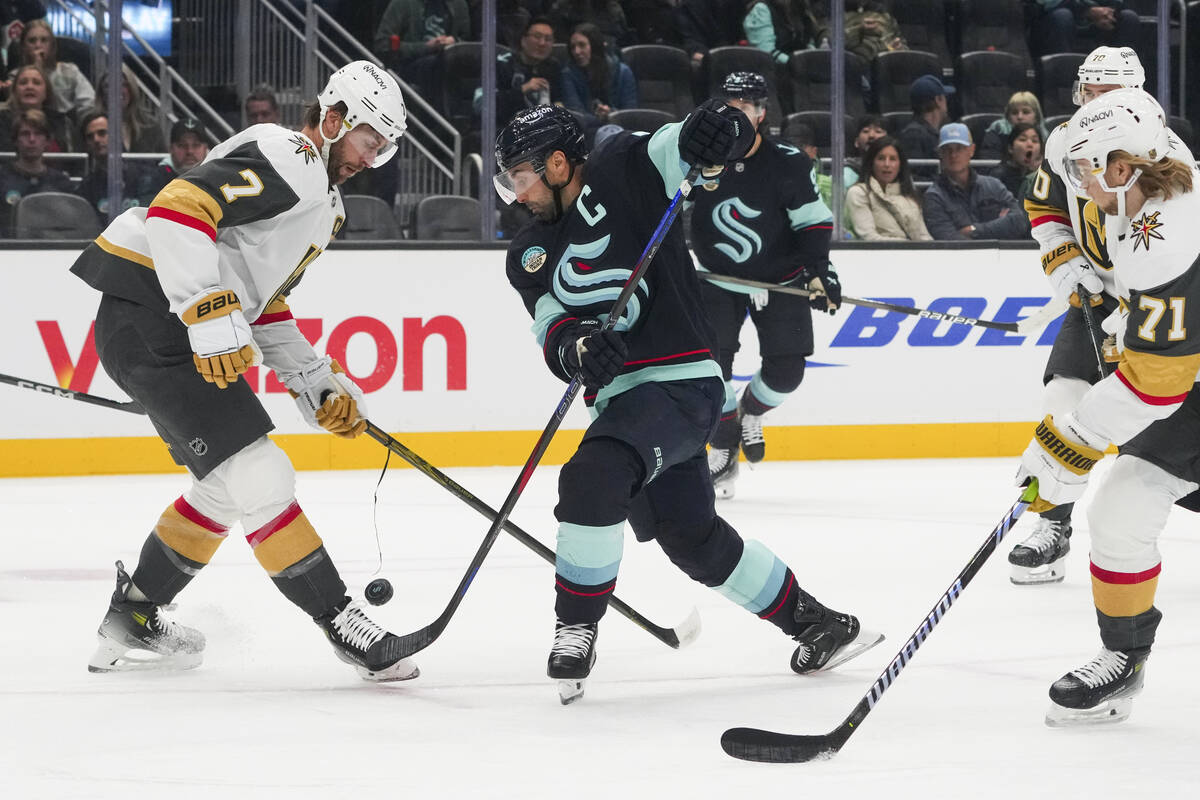 Vegas Golden Knights defenseman Alex Pietrangelo, left, looks down at the puck after stopping a ...