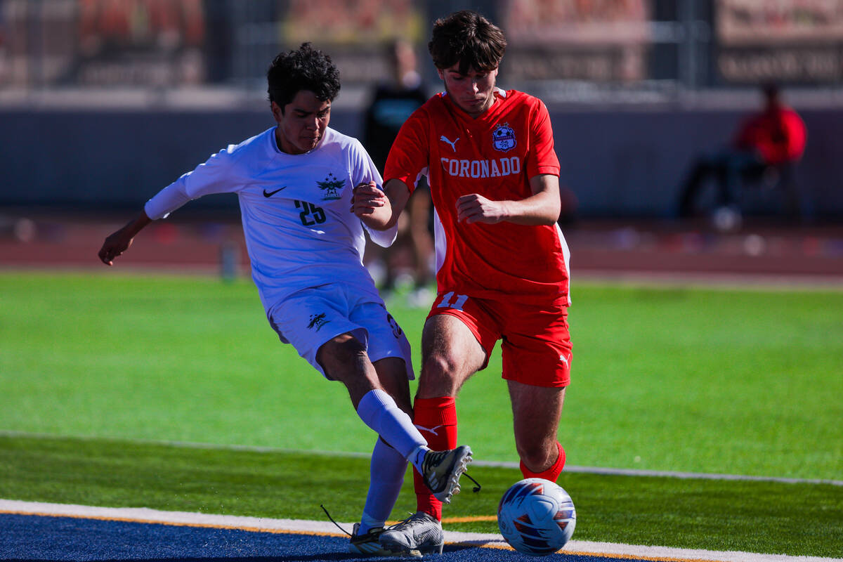 Hug defensive player Julian Enriquez (25) and Coronado striker Gavin Flickinger (11) battle it ...