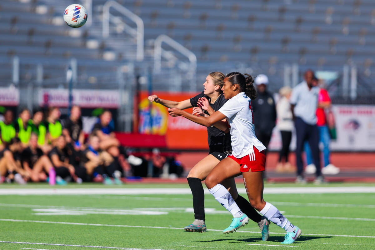 Faith Lutheran defensive player Kloe Abdalla (14) and Liberty midfielder Ayva Jordan (12) race ...