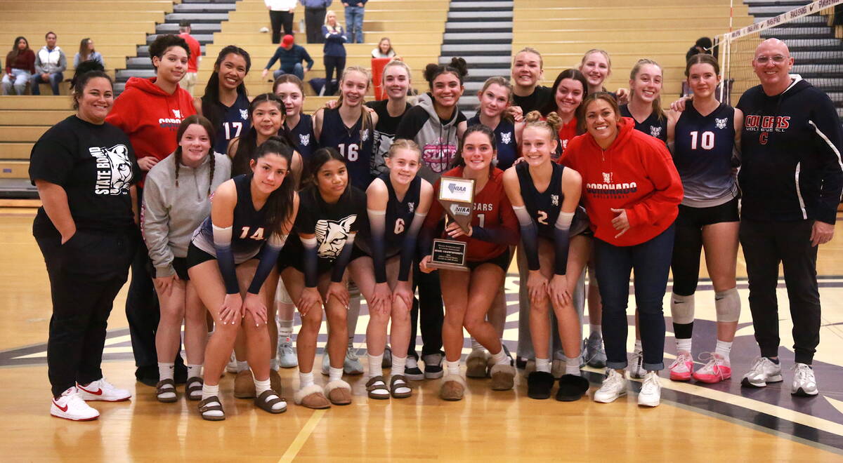 The Coronado High School volleyball team holds up its Class 5A state runner-up trophy after los ...