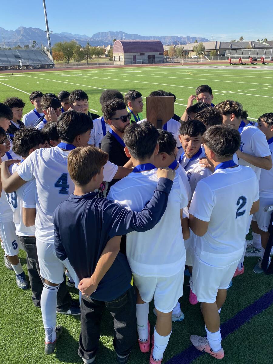 The Canyon Springs boys soccer team gathers around its trophy after winning the Class 4A state ...