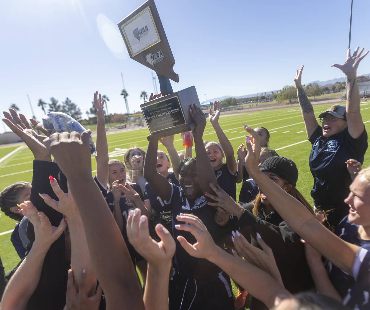 Centennial defender Natalie Penniston-John (11) holds up the trophy after winning the 4A girls ...