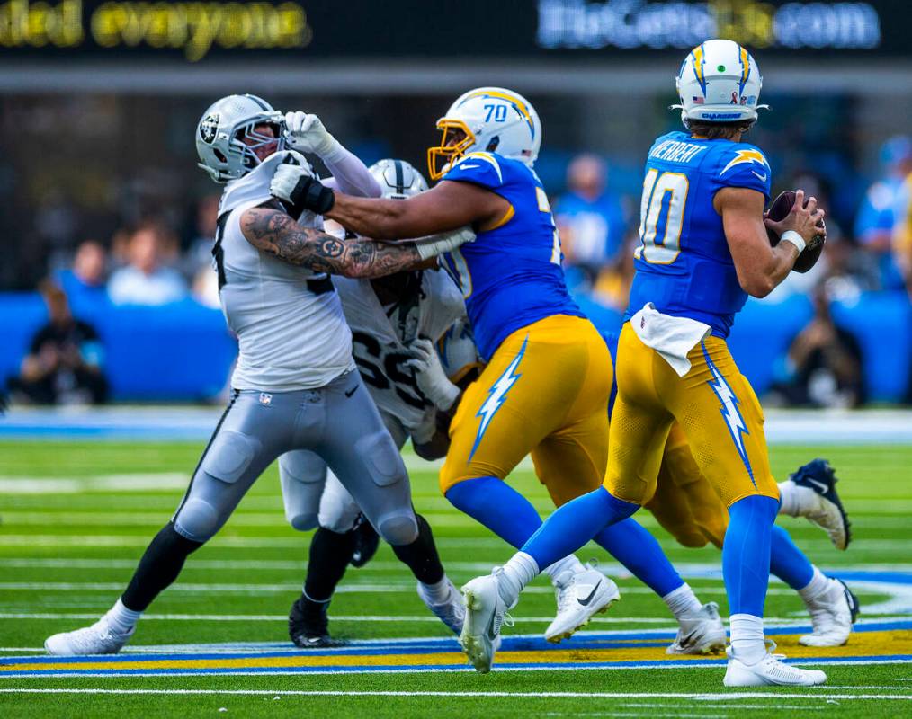 Raiders defensive end Maxx Crosby (98) is held again on crush by Los Angeles Chargers offensive ...