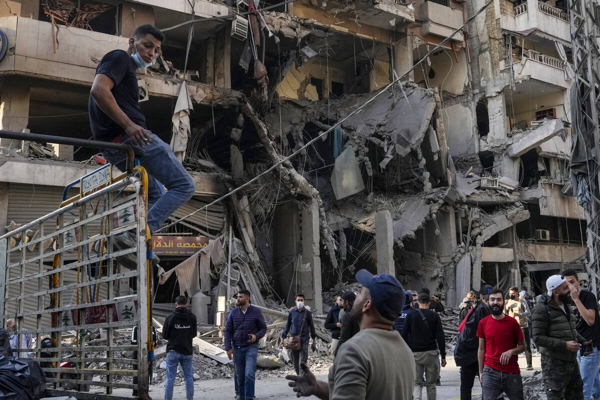 Residents check the site of an Israeli airstrike in Dahiyeh, Beirut, Lebanon, Saturday, Nov. 9, ...