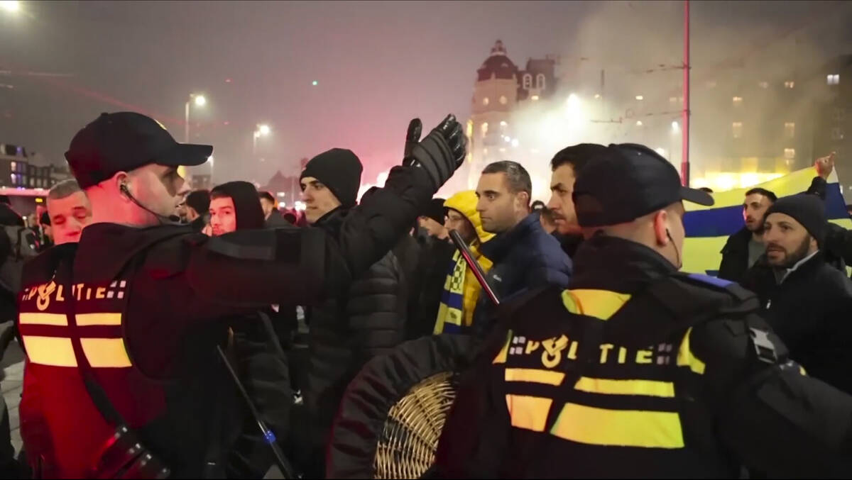 In this image taken from video, police escort Maccabi Tel Aviv supporters to the metro station ...