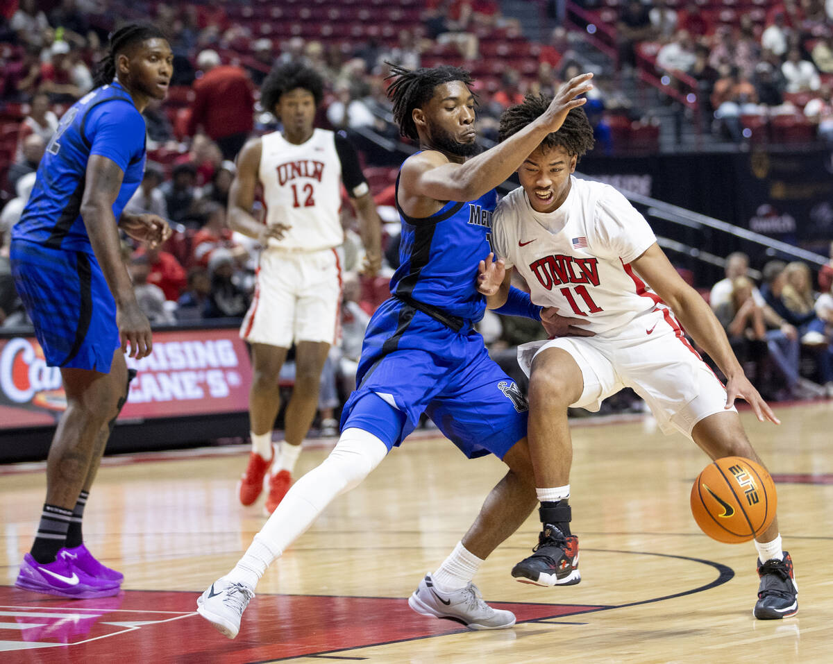 UNLV guard Dedan Thomas Jr. (11) and Memphis Tigers guard Tyrese Hunter, left, compete during t ...