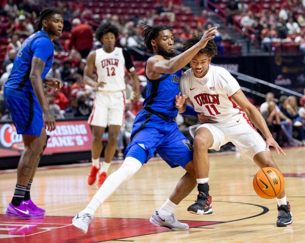 UNLV guard Dedan Thomas Jr. (11) and Memphis Tigers guard Tyrese Hunter, left, compete during t ...