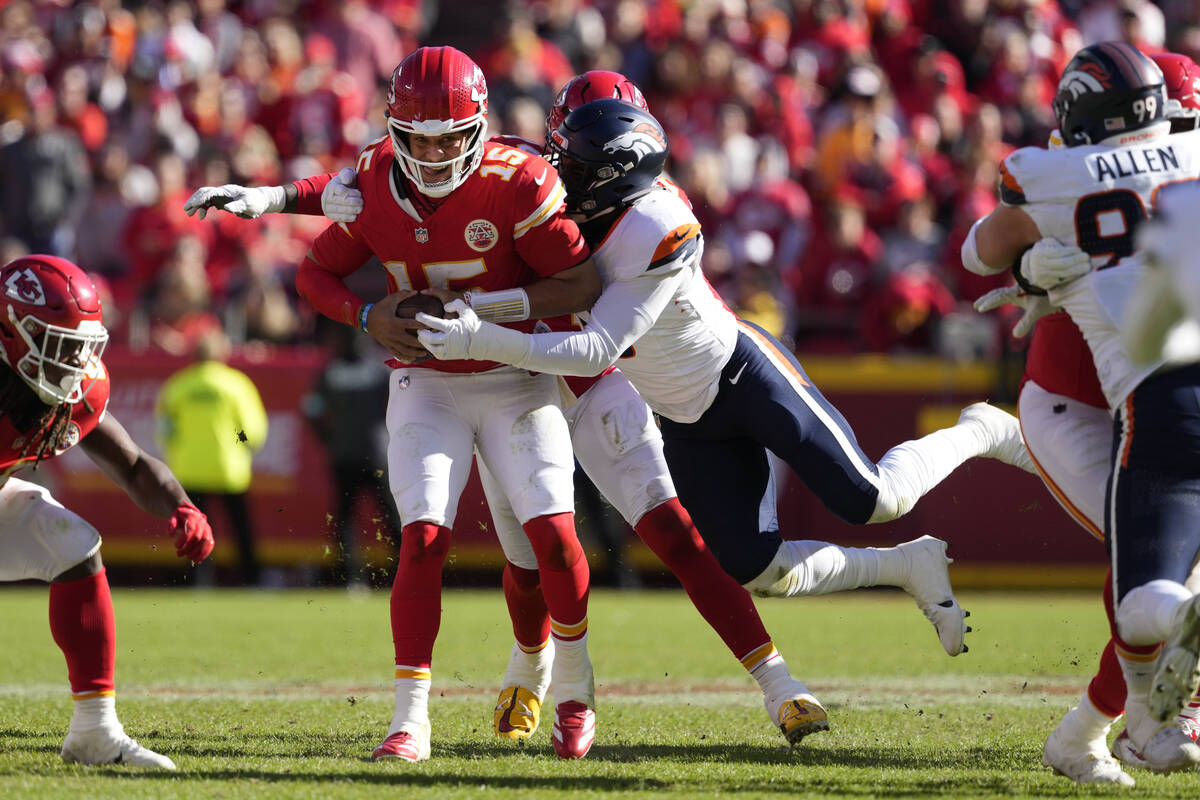 Kansas City Chiefs quarterback Patrick Mahomes (15) is stopped by Denver Broncos outside lineba ...