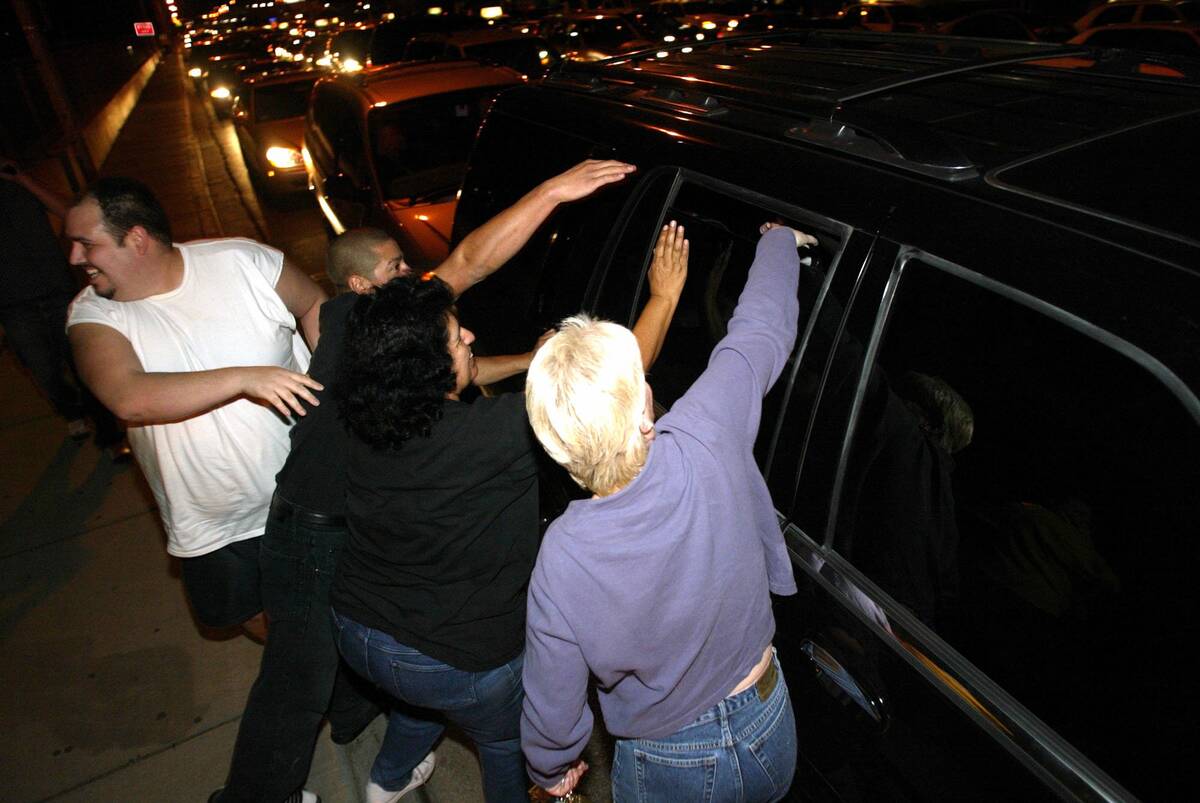 Michael Jackson fans try to touch the pop superstar through the window of his car Thursday, Nov ...