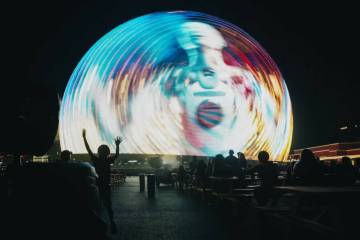 FILE - A child stays cool by a misting fan as the Sphere displays a show on Thursday, July 4, 2 ...