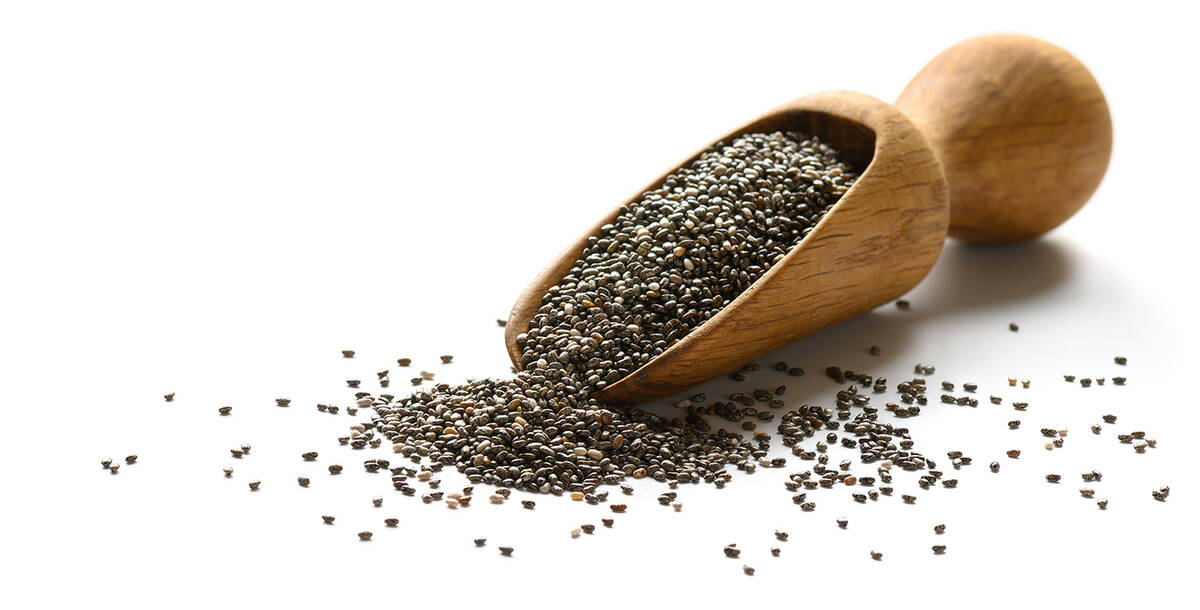 Chia seeds in a wooden scoop isolated on white background