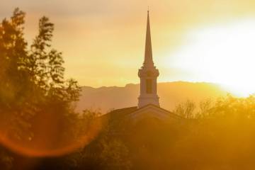 FILE - The sun sets behind The Church of Jesus Christ of Latter-day Saints on Friday, Aug. 23, ...