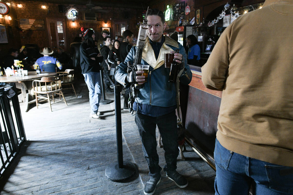 David Broido balances drinks and a “syringer” rifle during the Fallout Fan Celebr ...