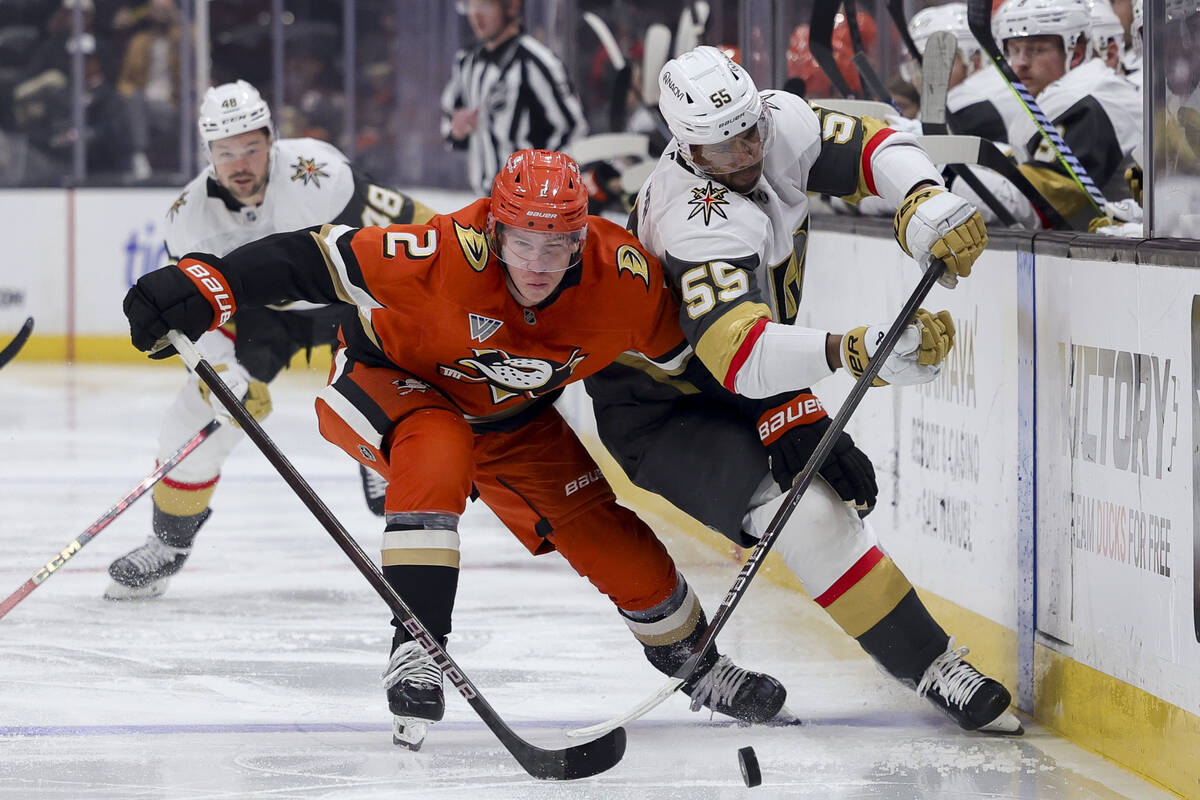 Anaheim Ducks defenseman Jackson LaCombe, left, and Vegas Golden Knights right wing Keegan Kole ...