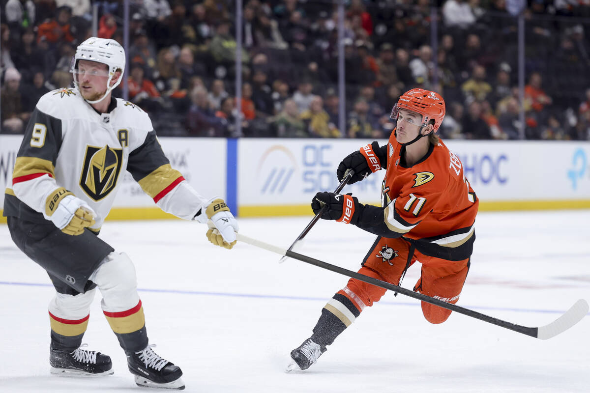 Anaheim Ducks center Trevor Zegras, right, watches his shot next to Vegas Golden Knights center ...