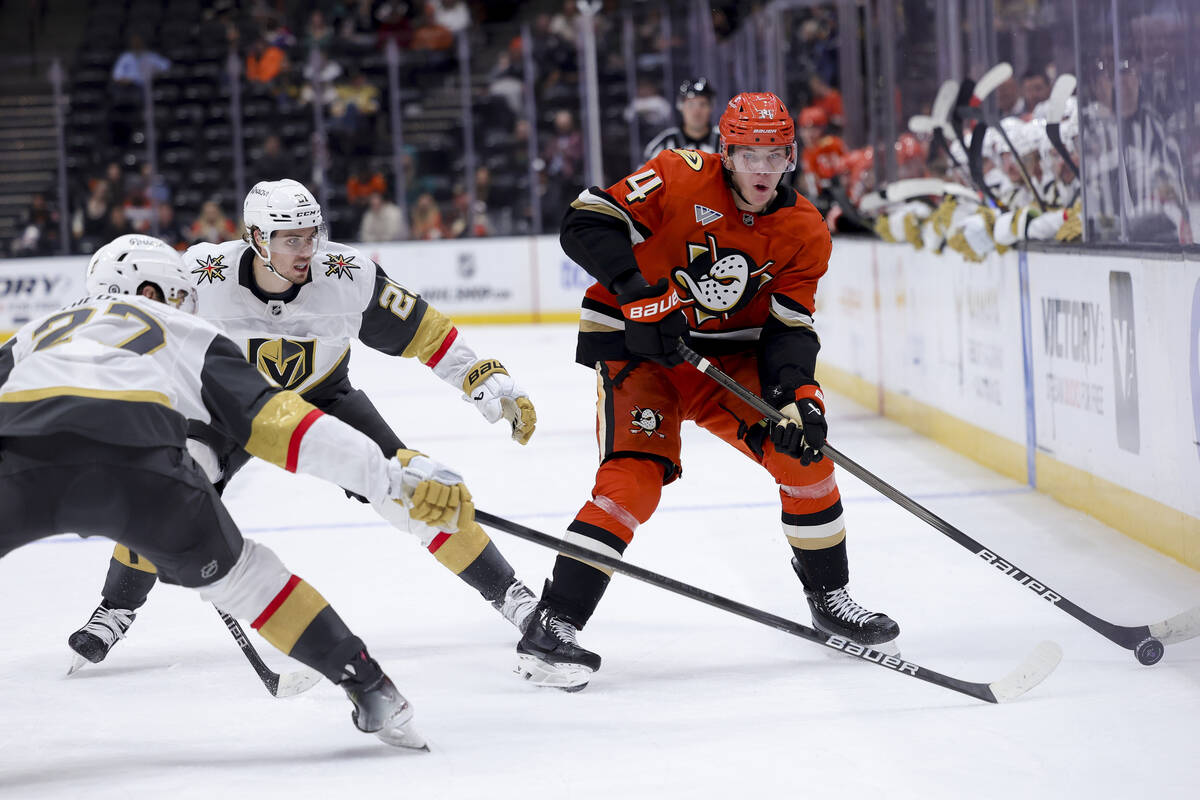 Anaheim Ducks defenseman Pavel Mintyukov, right, vies for the puck against Vegas Golden Knights ...