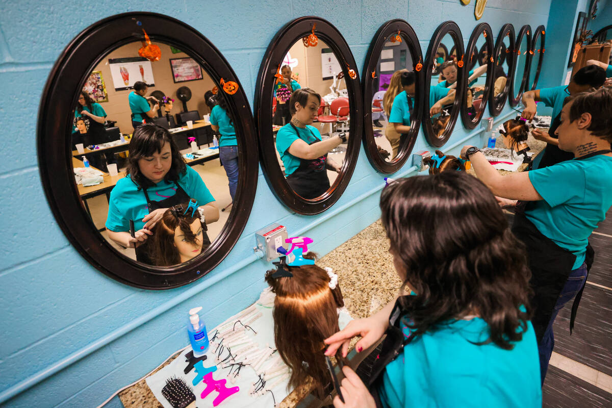 Students practice perms on mannequins during a cosmetology class at Florence McClure Women&#x20 ...