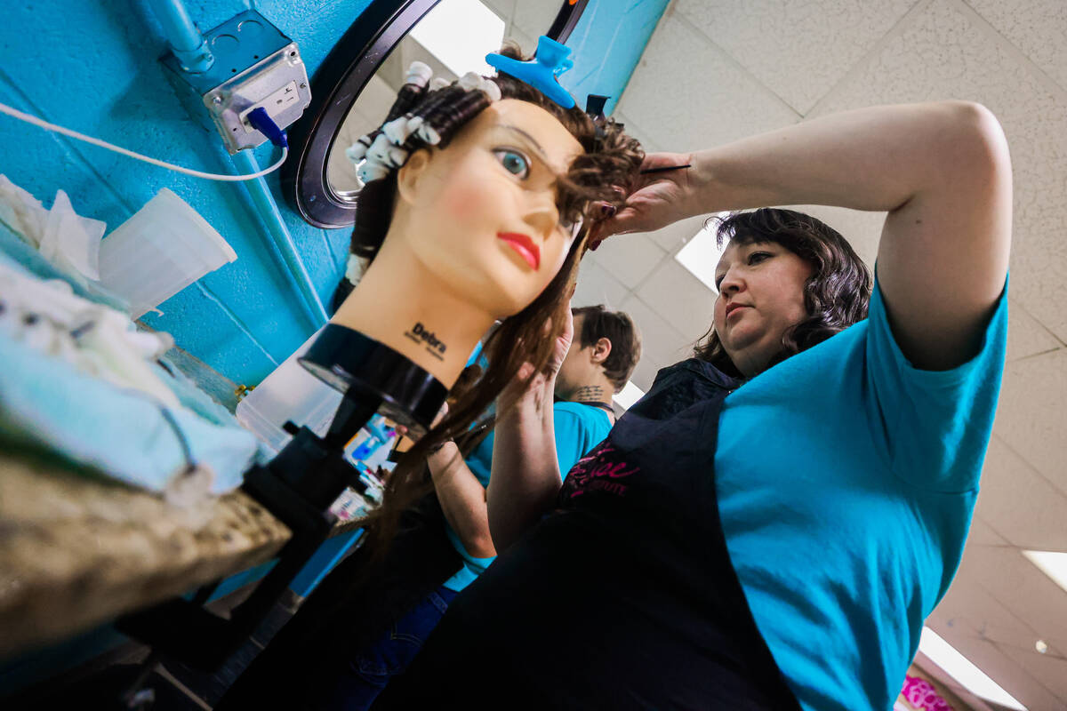 Emily Ikuta practices a perm on a mannequin during a cosmetology class at Florence McClure Wome ...