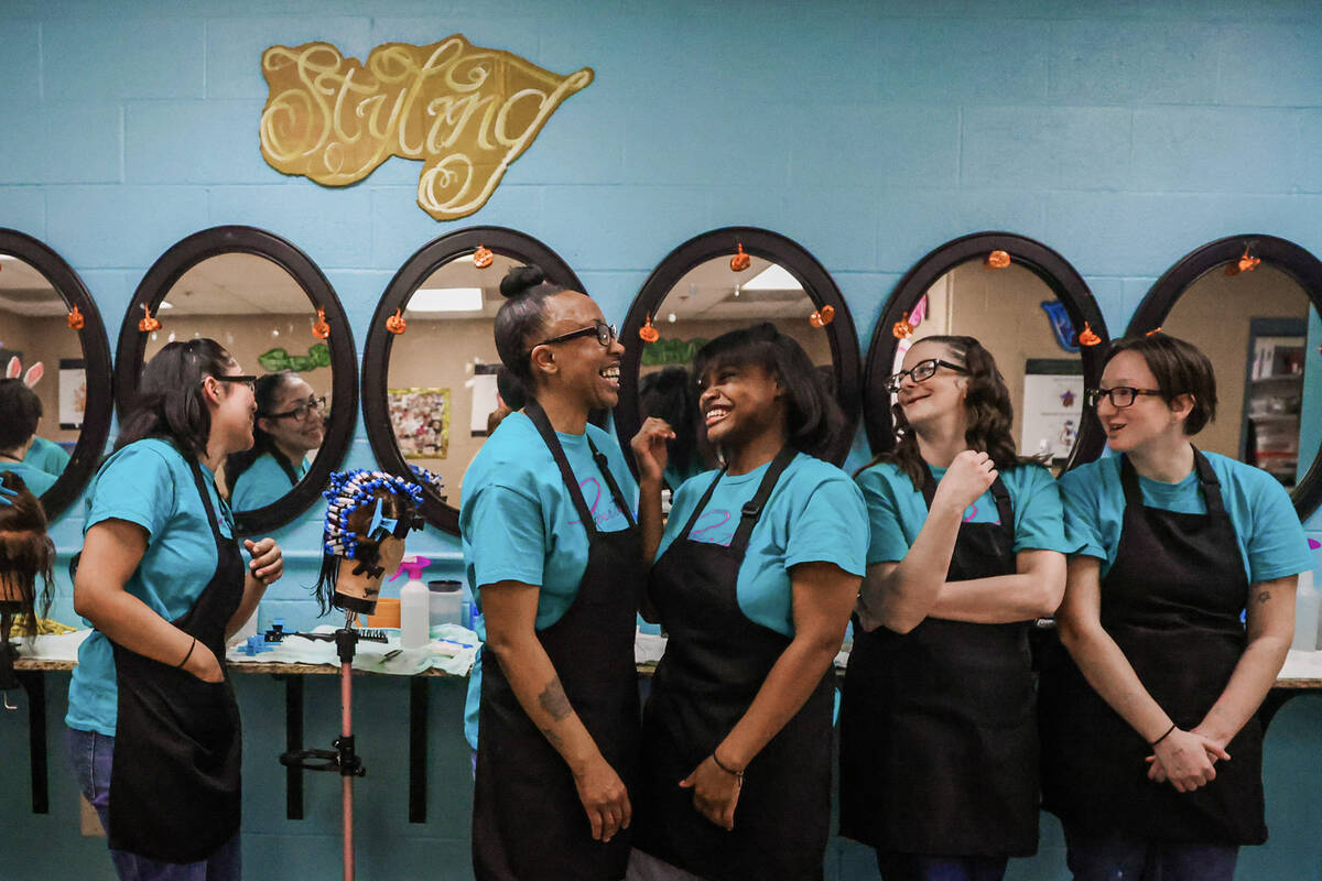 Inmate students who are training for their cosmetology licenses share a laugh during a cosmetol ...