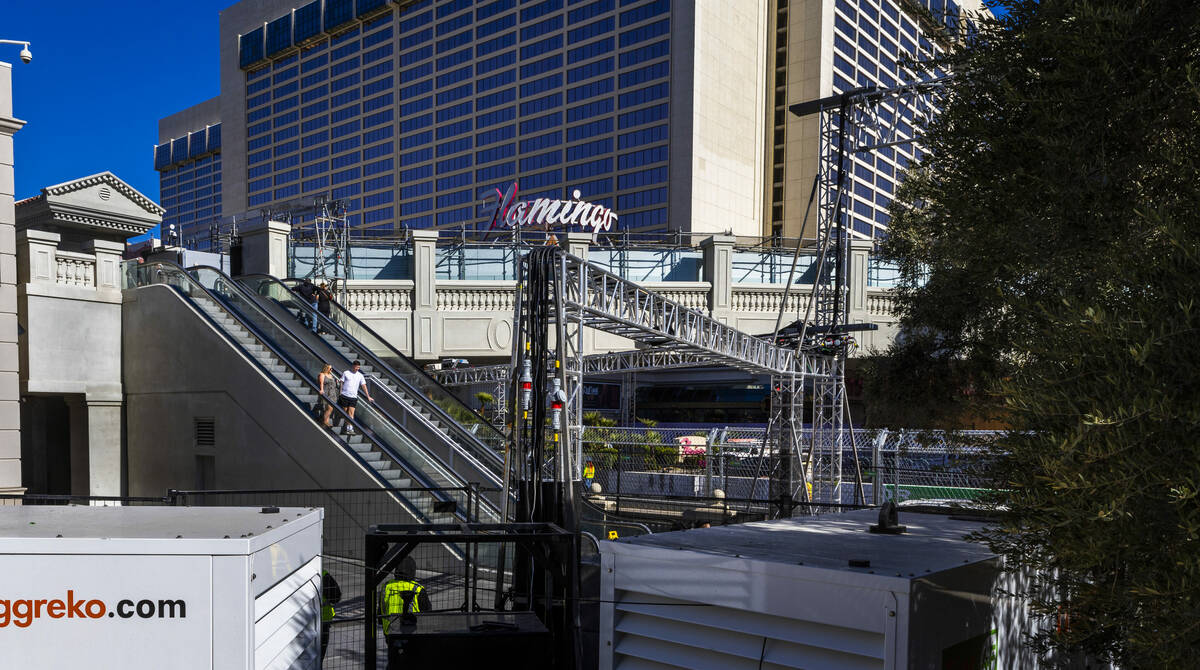 People come down from a pedestrian bridge walled off over Las Vegas Boulevard at Flamingo Road ...