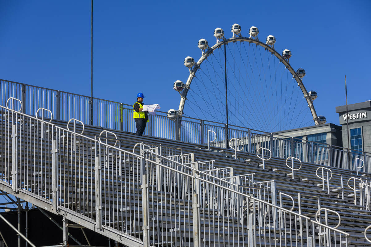 A worker stands atop one of the temporary grandstands along Koval Lane as F1 infrastructure con ...