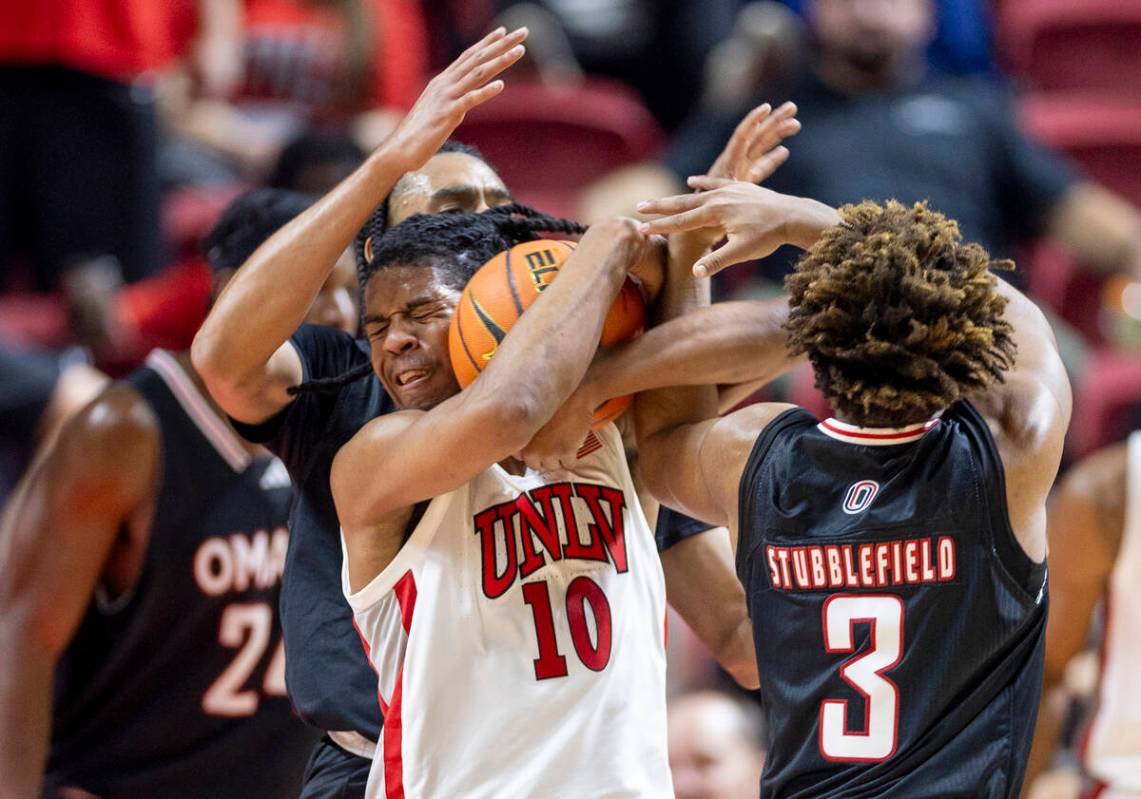 UNLV guard Dedan Thomas Jr. (11) holds his mouth after being elbowed in the face by Omaha Maver ...