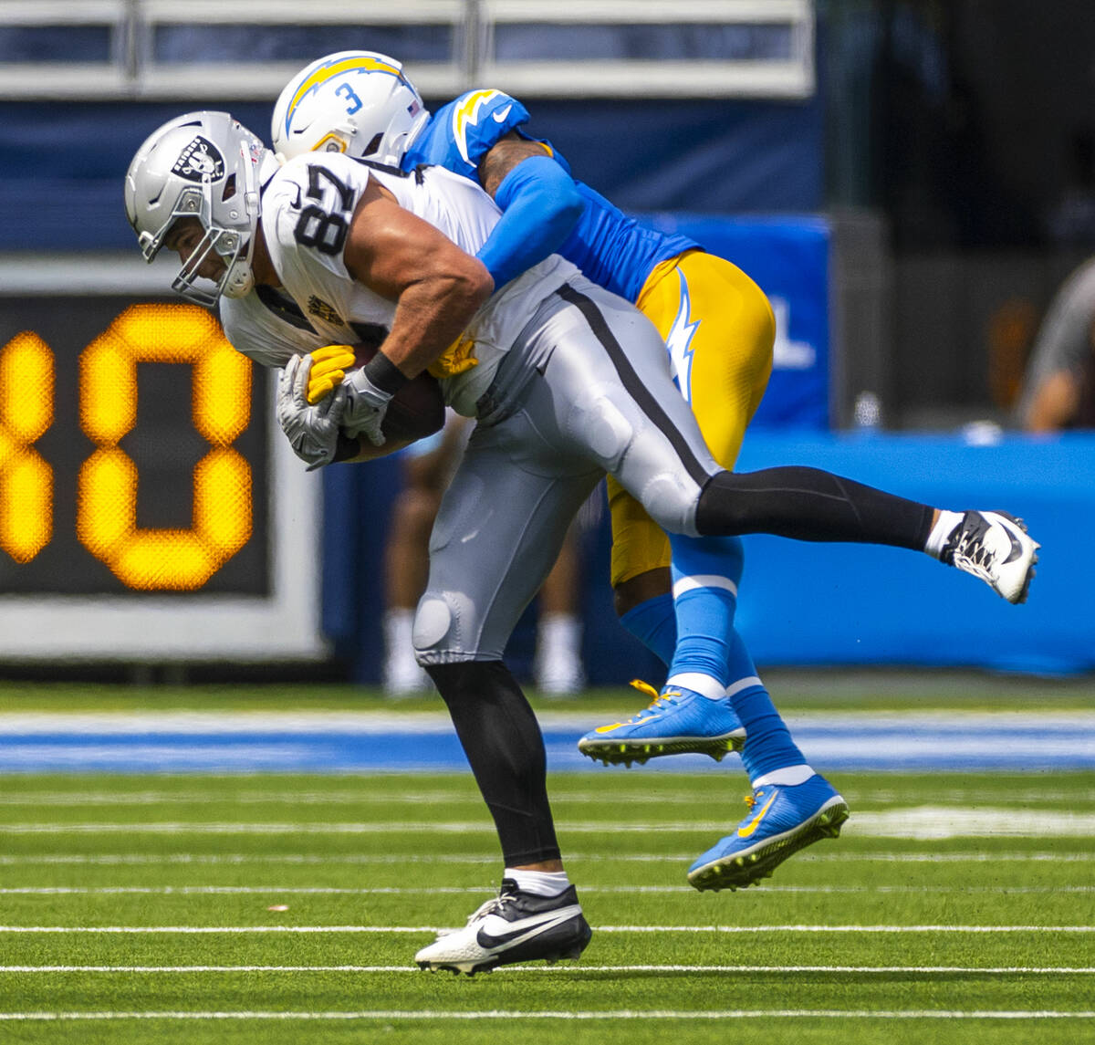 Raiders tight end Michael Mayer (87) secures a catch over Los Angeles Chargers safety Derwin Ja ...