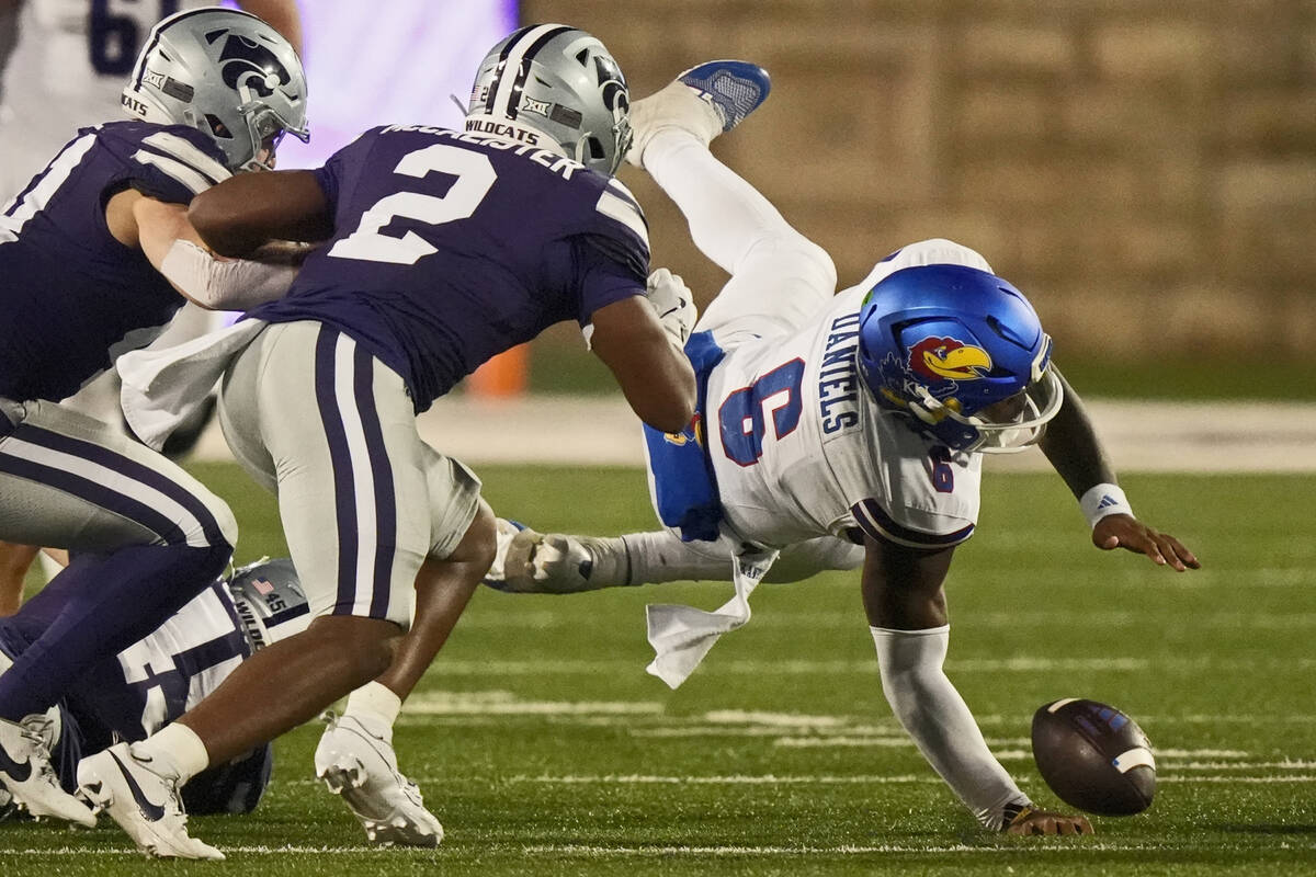 Kansas quarterback Jalon Daniels (6) fumbles the ball after being tackled by Kansas State lineb ...