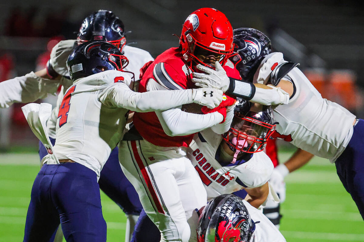 Arbor View running back Kamareion Bell (0) carries the ball through a group of opposing players ...