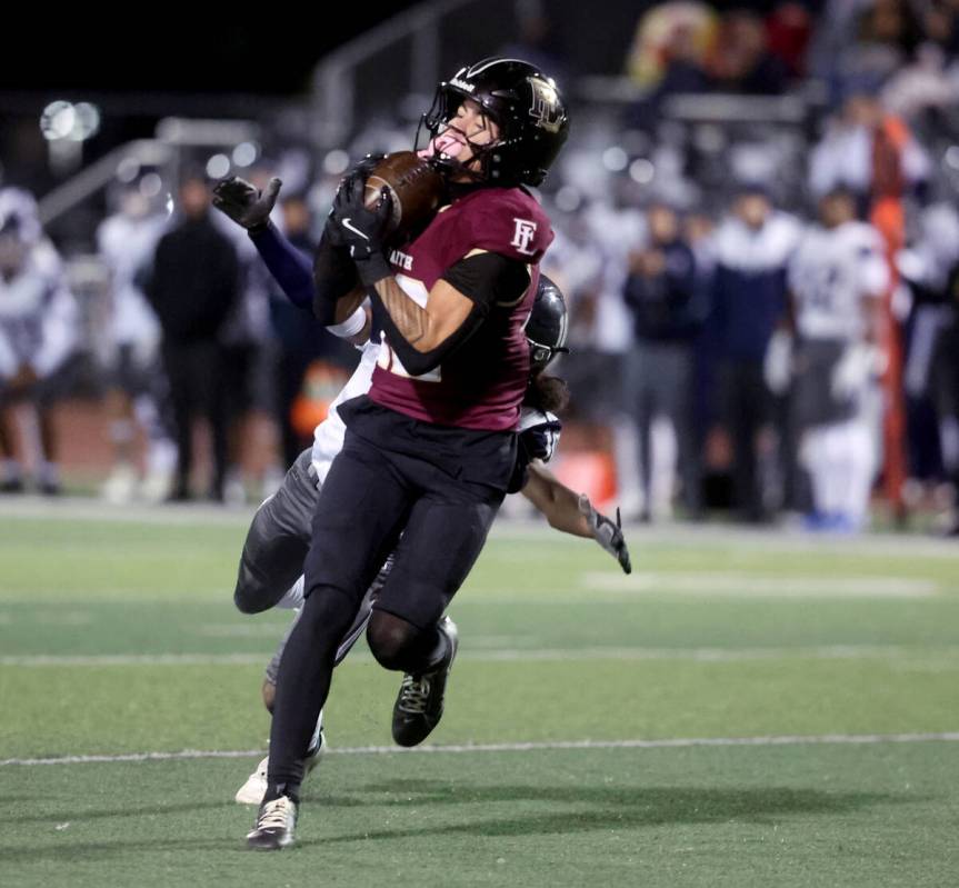 Faith Lutheran wide receiver Aipa Kuloloia (12) catches a pass against Shadow Ridge in the firs ...