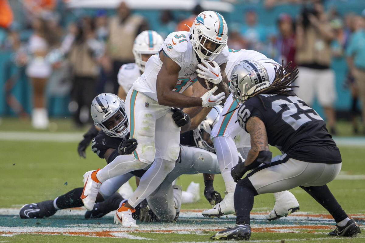 Raiders linebacker Divine Deablo (5) tries to bring down Miami Dolphins running back Raheem Mos ...