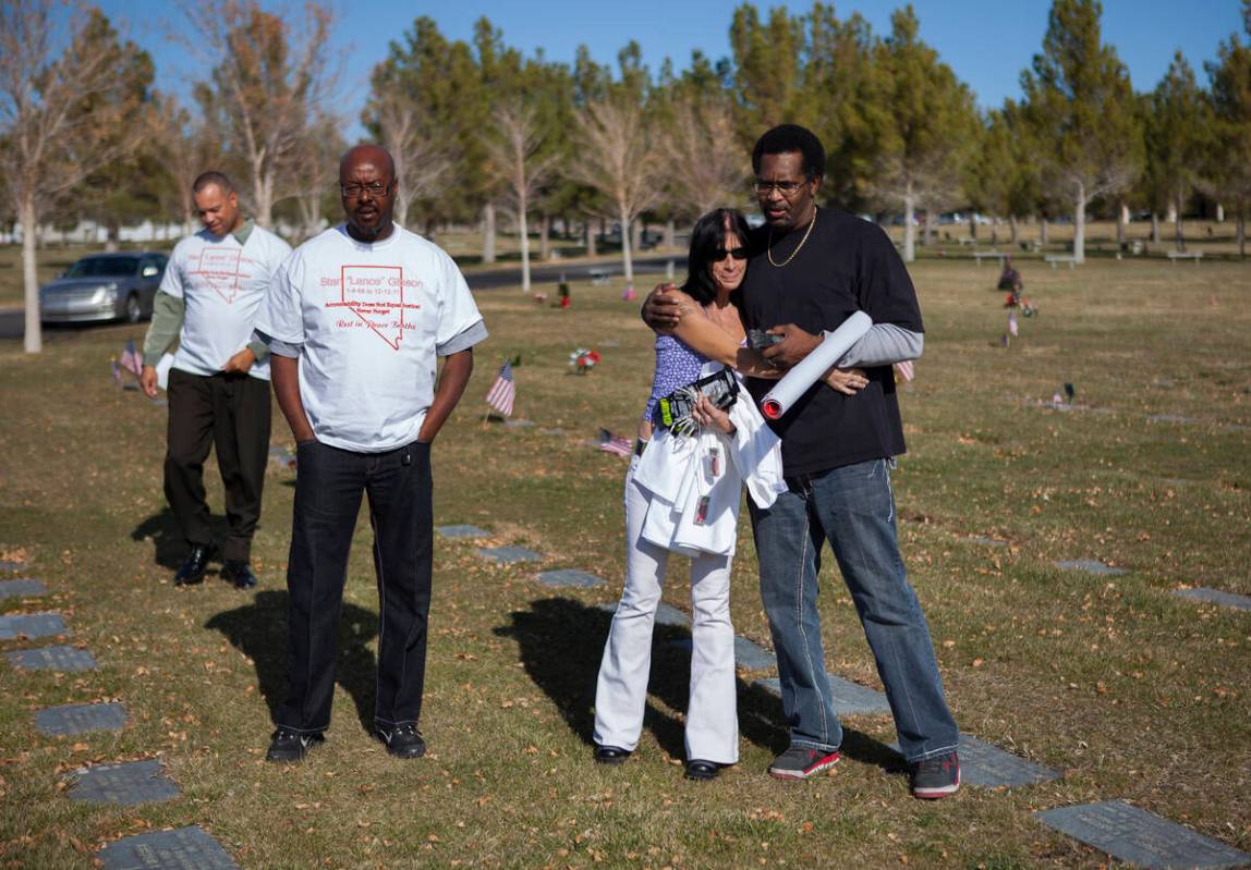 Todd Hudson, right, hugs Rondha Gibson as they visit the grave of Rondha's husband Stanley Gibs ...