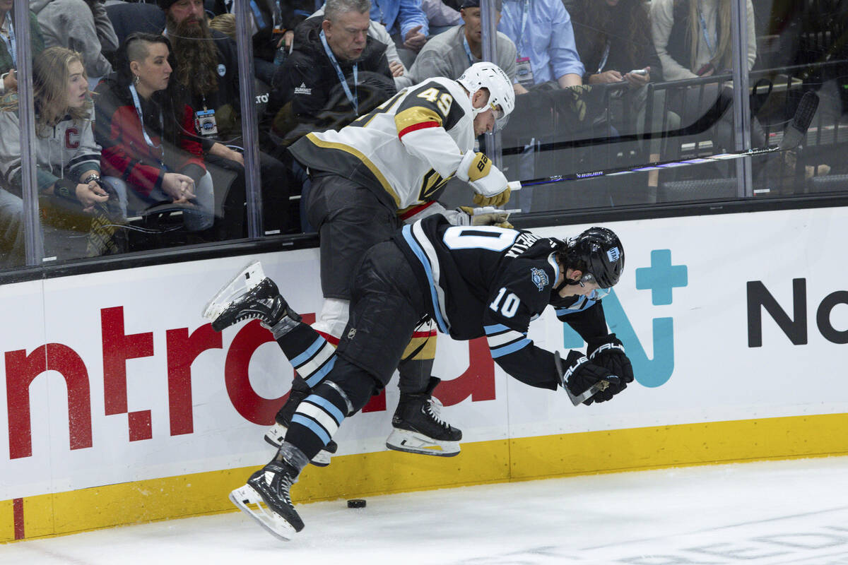 Vegas Golden Knights center Ivan Barbashev (49) fights for the puck against Utah Hockey Club de ...